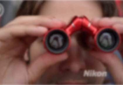 This is a photograph of a man looking through binoculars.